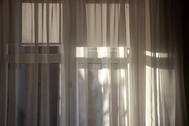 Yumuşak güneş ışığı perdelerin arasından süzülüp sıcak ve davetkar bir atmosfer yaratır. İç tasarım projeleri ve ev dekorasyonu için mükemmel..