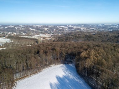 Karla kaplı tarlaların ve ormanların hava manzarası kış manzaralarının dingin güzelliğini gözler önüne seriyor. Doğa ve seyahat temaları için mükemmel.