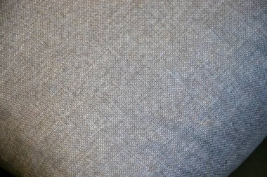 Tasarım ve tekstil uygulamaları için ideal desenli gri kumaşın yakın çekimi. İnce dokuma iç dekorasyon için sofistike bir atmosfer yaratır..