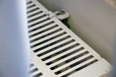 Beyaz ısıtma radyatörünün yakın plan görüntüsü şebeke desenini ve tasarımını gösteriyor. Ev geliştirme iç tasarım veya emlak projeleri için ideal.