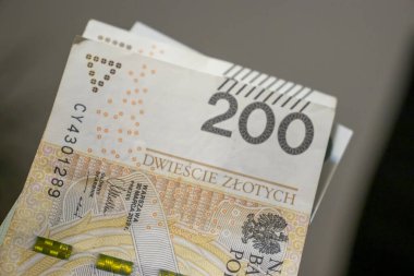 Polonya 200 zloti banknotunun yakın plan çekimleri detaylı güvenlik özellikleri ve tasarımı gösteriyor. Finansal temalar ve para birimi tartışmaları için mükemmel.