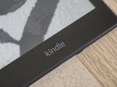Varşova Polonya - 15 Ekim 2024: Bir Kindle e-okuyucusunun yakın çekimi ahşap bir yüzey üzerinde parlak tasarımı ve dijital görüntüsünü sergiliyor. Okuma meraklıları ve teknoloji severler için mükemmel..