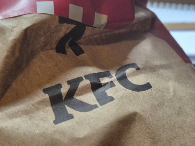 Varşova Polonya - 15 Ekim 2024: KFC çantasının yakın çekimi, fast food kültürünün özünü yansıtan ikonik logoyu gösteriyor. Lezzetli yemeklerin tadını çıkarın..