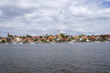 Mikolajki Polonya - 29 Eylül 2024: Mikolajki 'nin deniz kenarındaki renkli binaları ve bu popüler varış yerinin cazibesini gösteren manzaralı tekneleri ile görkemli bir görüntüsü.