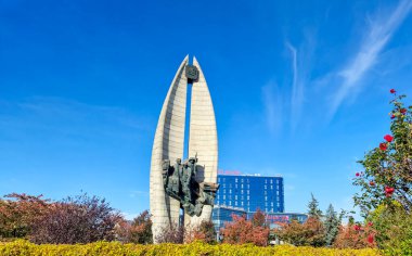 Rzeszow Polonya - 15 Ekim 2024: Renkli ağaçlar ve modern binalarla çevrili çarpıcı bir anıt Rzeszow 'un tarih ve çağdaş mimarinin karışımını sergiliyor.