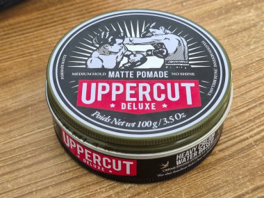 Varşova Polonya - 15 Aralık 2024: Ahşap bir yüzey üzerindeki Uppercut Deluxe Potte 'un yakın çekimi, modacılara özel tasarımını ve markasını sergilemektedir..