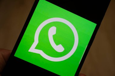 Warsaw Poland - January 17 2025: Close-up of a smartphone displaying the WhatsApp logo on a vibrant green background symbolizing communication and connectivity. clipart