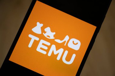 Varşova Polonya - 17 Ocak 2025: Temu logosu modern alışverişi sembolize eden akıllı telefon ekranında sergilendi. Canlı turuncu arka plan logonun oyuncu ve davetkar karakterini arttırır..
