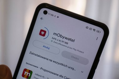 Varşova Polonya - 17 Ocak 2025: mObywatel uygulamasının indirme durumunu gösteren bir akıllı telefon ekranı. Teknoloji ve dijital servis temaları için ideal.