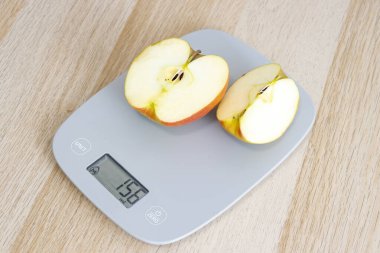 Modern mutfak ölçeğine göre kesilmiş bir elma ağırlığı 156 gram. Sağlık ve beslenme temaları için mükemmel.
