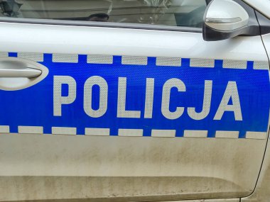 Wroclaw Polonya - 23 Şubat 2025: POLICJA sözcüğünün yer aldığı ve kolluk kuvvetleri kimliği ve araç tasarımı gösteren bir polis aracının kapısı.