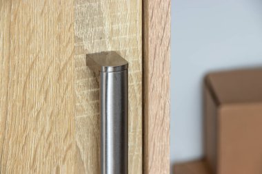 Ahşap bir yüzey üzerinde modern bir kapı kolunun yakın plan parlak tasarımı ve dokusu. İç dekorasyon ve mimari temalar için mükemmel..