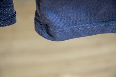 Mavi gömlekli kumaş kaplamalı kumaş yakın plan ve yumuşak arka planda dikişler. Moda veya tekstil projeleri için mükemmel.