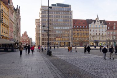 Wroclaw Polonya - 21 Şubat 2025: Kültür ve turizm promosyonları için ideal modern ve tarihi mimariye sahip yayalarla dolu canlı bir şehir meydanı.