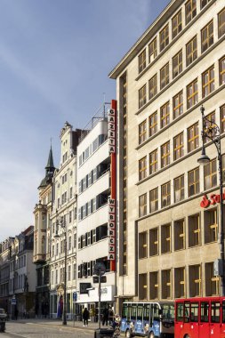 Wroclaw Polonya - 21 Şubat 2025: Gazeta Wyborcza 'nın modern mimariyi geleneksel şehir hayatı ile birlikte inşa ettiği canlı bir sokak manzarası.