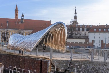 Wroclaw Polonya - 23 Şubat 2025: Rıhtımdaki modern Nawa heykeli güneşli bir günde ziyaretçileri çeken mimariyi yansıtıyor.
