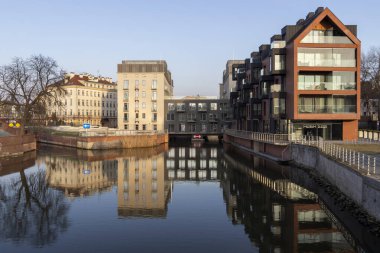 Wroclaw Polonya - 23 Şubat 2025: Gündüz gösteriminde sakin sulara yansıyan modern liman binaları kentsel mimari ve sakin ortam.