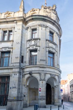 Wroclaw Polonya - 23 Şubat 2025: Wroclaw 'da canlı bir caddede detaylı mimarisi olan zarif bir tarihi bina bir kültür karışımı sergiliyor.