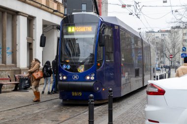 Wroclaw Polonya - 23 Şubat 2025: Şehir merkezinde faaliyet gösteren modern bir tramvay kalabalık bir metropolde kentsel taşımacılık sergiliyor