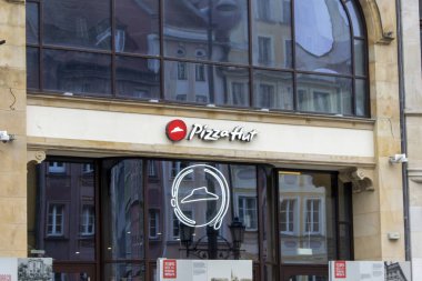 Wroclaw Polonya - 23 Şubat 2025: Pizza Hut restoran cephesi yakınlardaki mimari ve canlı kentsel atmosferi yansıtan parlak tabelalı büyük pencereler.