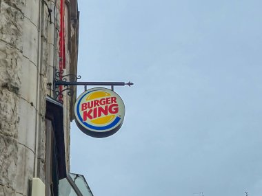 Wroclaw Polonya - 23 Şubat 2025: Burger King, şehir mimarisi ve bulutlu gökyüzü arasında fast food markalaşması gösteren bir binada imza attı.