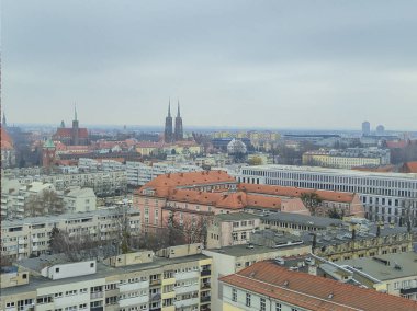 Wroclaw Polonya - 23 Şubat 2025: Wroclaw şehrinin panoramik manzarası geleneksel mimari ve modern binaları bulutlu gökyüzü altında sergiliyor