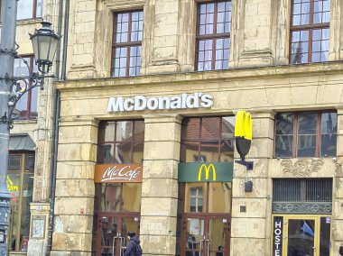 Wroclaw Polonya - 23 Şubat 2025: Wroclaw 'daki McDonald' s ve McCafe 'nin dış görünüşü Fast food kültürünü gözler önüne seriyor.