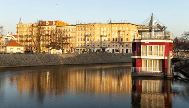 Wroclaw Polonya - 23 Şubat 2025: Odra Nehri boyunca uzanan tarihi binaların manzarası kışın altın saatinde suya yansıyor