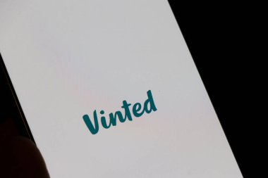 Varşova Polonya - 10 Mart 2025: Vinted logosunu gösteren akıllı telefon ikinci el eşya alıp satmak için popüler bir dijital platform.