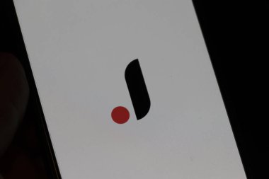 Varşova Polonya - 10 Mart 2025: Teknoloji ve tasarım yeniliklerini sembolize eden minimalist bir arka planda modern bir logo gösteren akıllı telefon ekranının yakın görüntüsü.