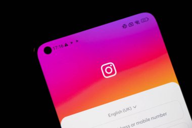 Varşova Polonya - 10 Mart 2025: Instagram giriş ekranını canlı pembe gradyan arkaplan ile gösteren akıllı telefonun yakın görüntüsü.