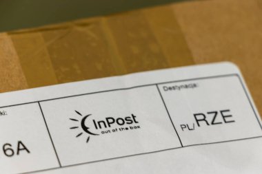 Varşova Polonya - 12 Mart 2025: Polonya 'da InPost logosu ve teslimat adresinin yer aldığı bir nakliye paketinin yakından görüntüsü.