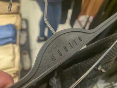 Przemysl Polonya - Mart 12025: Perakende ortamda giysi gösteren Mohito marka siyah elbise askısı.