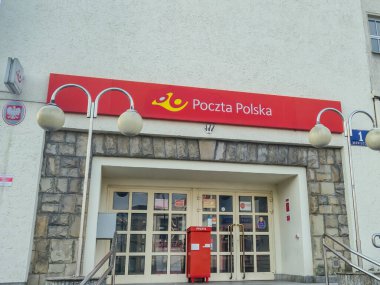 Rzeszow Polonya - 2 Mart 2025: Poczta Polska postanesinin dış görünüşü posta hizmetlerini sembolize eden kırmızı tabela ve girişini gösteriyor.