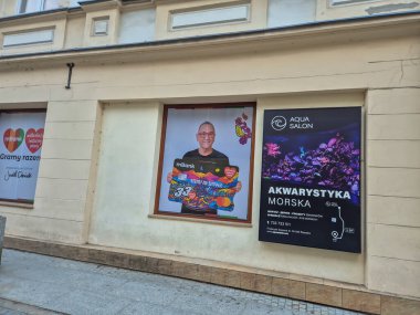 Rzeszow Polonya - 2 Mart 2025: Bir şehir caddesinde mBank hizmetlerini destekleyen renkli bir tabela tutan gülümseyen bir adamın reklamı.