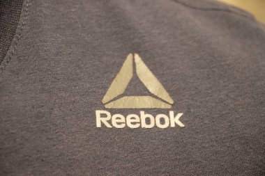 Varşova Polonya - 3 Mart 2025: Spor ve spor için uygun modern bir tasarımı sergileyen koyu renk kumaş bir giysinin üzerindeki Reebok logosunun yakın çekimi.