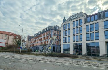 Wroclaw Polonya - 23 Şubat 2025: Şehir mimari görüşü bulutlu bir gökyüzü altında tarihi ve modern binaların bir karışımını sergiliyor.