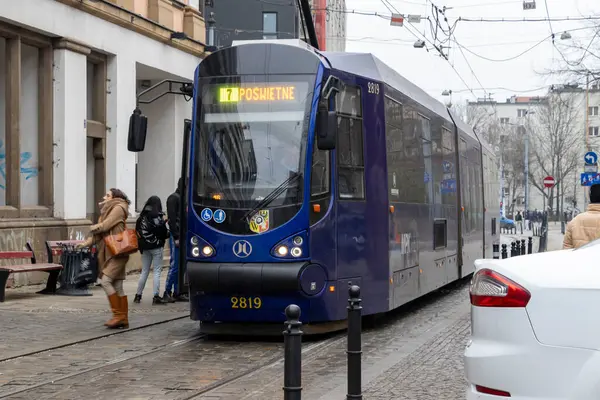 Wroclaw Polonya - 23 Şubat 2025: Şehir merkezinde faaliyet gösteren modern bir tramvay kalabalık bir metropolde kentsel taşımacılık sergiliyor