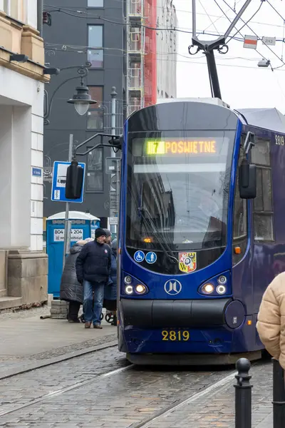 Wroclaw Polonya - 23 Şubat 2025: Modern bir tramvay, kış mevsiminde toplu taşımacılık sergilenen kentsel alanda yoğun bir durağa yaklaşıyor.