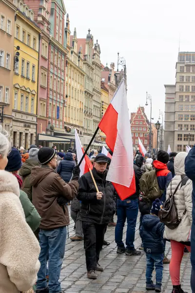 Wroclaw Polonya - 23 Şubat 2025: Polonya bayraklarıyla sokaklarda gösteri yapan insanlar, canlı bir şehir ortamında birlik ve ulusal gurur gösteriyorlar.