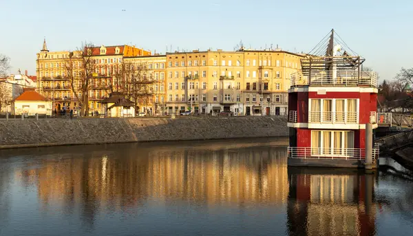 Wroclaw Polonya - 23 Şubat 2025: Odra Nehri boyunca uzanan tarihi binaların manzarası kışın altın saatinde suya yansıyor