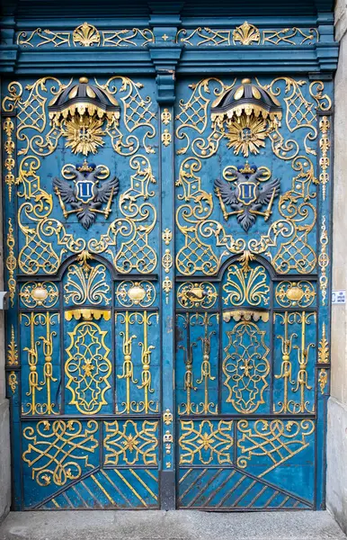 Wroclaw Polonya - 23 Şubat 2025: Süslü mavi ve altın kapılar, karmaşık işçilik ve kültür mirası sergilenen tarihi bir binayı süslüyor