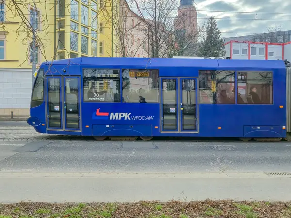 Wroclaw Polonya - 23 Şubat 2025: MPK Wroclaw damgalı mavi bir tramvay bir şehir merkezinde toplu taşımaya hizmet ederken görülüyor.