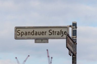 Spandauer Caddesi ve Rathausstrasse için sokak işaretleri Berlin 'deki bir bulut arkaplanına karşı bir direkte sergilendi..