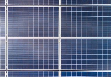 Güneş panelleri, modern teknoloji ve çevresel koruma için sürdürülebilir enerji çözümlerini temsil eden güneş ışığını yakalayan ızgara desenli bir düzende dizilmiştir..