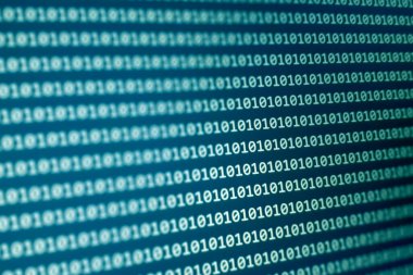 Modern bilgisayar ortamlarında veri işleme ve teknolojiyi temsil eden bir dijital ekranda gösterilen ikili kodun yakın görüntüsü.