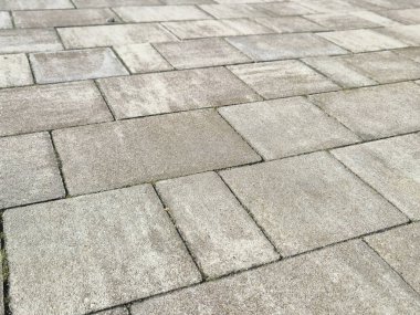 Dokulu kaldırım taşlarının yakın görüntüsü modern kentsel bir ortamda doğal ışık altında dayanıklı bir açık yüzey sağlıyor..