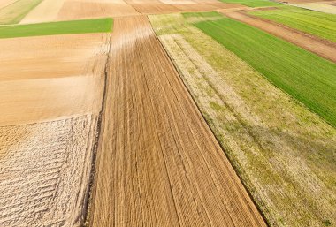 Canlı dokuları ve renkleri gösteren ekili tarlaların havadan görünüşü temiz gökyüzünün altında ekilmeye hazır el değmemiş tarım arazilerini gösteriyor..