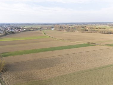 Gündüz vakti tarım ve doğa kavramları için ideal kırsal arazileri gösteren yeşil yamalı ve kahverengi toprağın uçsuz bucaksız tarım sahalarının havadan görünüşü.