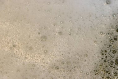 Bol köpük ve baloncukların yakın çekimi editoryal bağlamlarda temizliği veya ferahlatıcı içecekleri göstermek için dokulu bir yüzey yaratıyor.